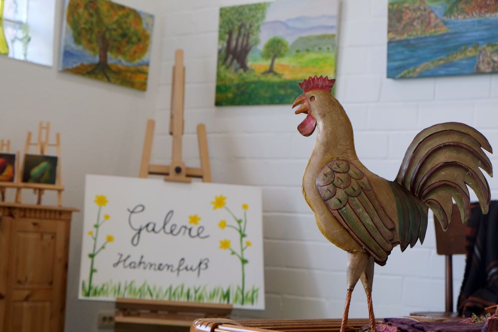 Blick in die Galerie Hahnenfuß mit Hahn und Gemälden im Hintergrund